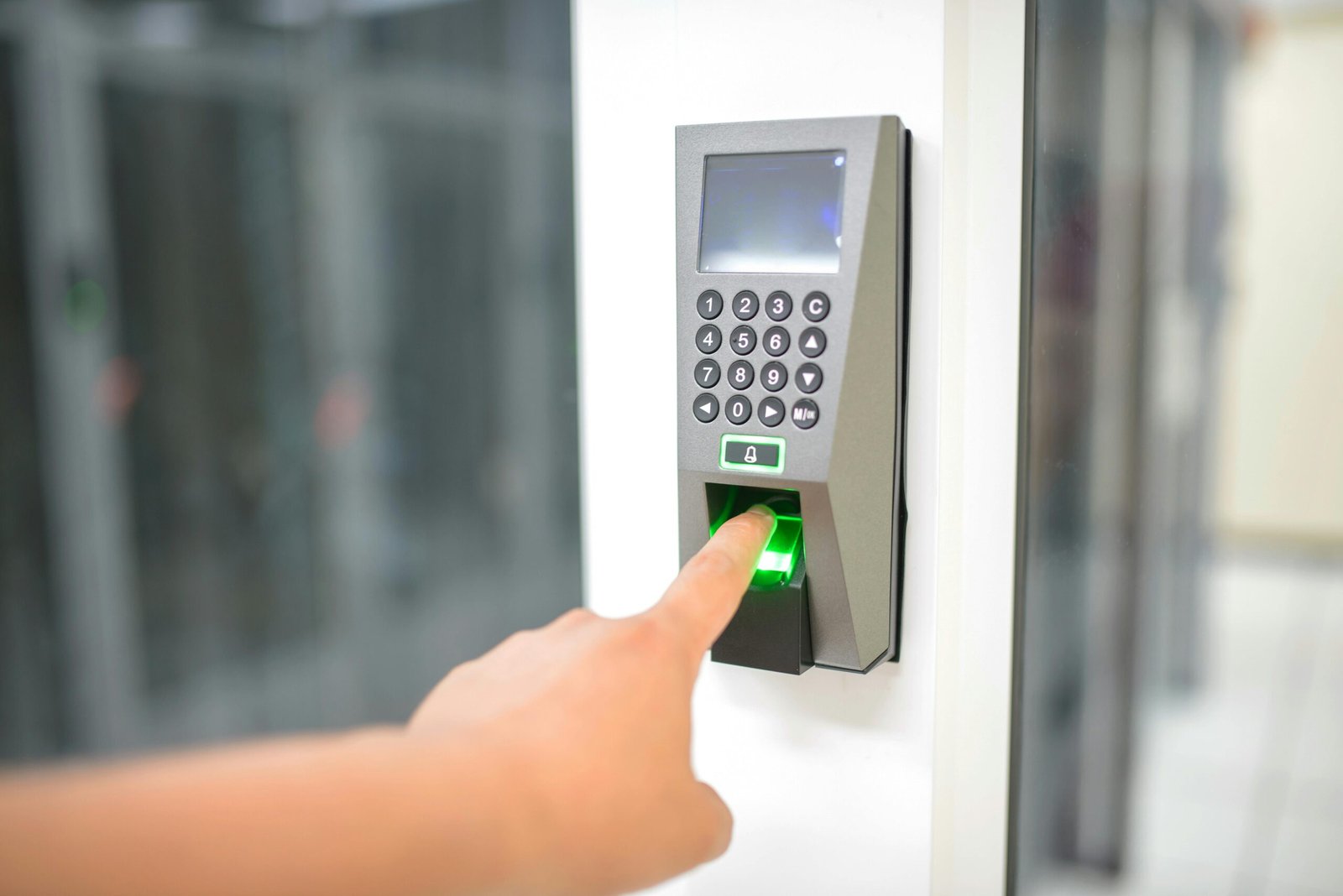 Home A person uses a fingerprint scanner for secure entry in a business setting.